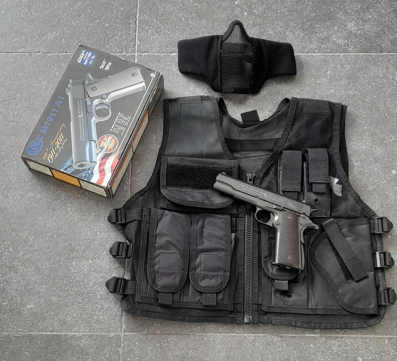 Afbeelding 1 van 1911 met tactical vest en masker.