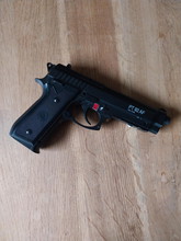 Imagen para Cybergun PT92 AF 6mm met Weapon light Olight Baldr Pro, zak met balletjes en 4 Cartouches CO2