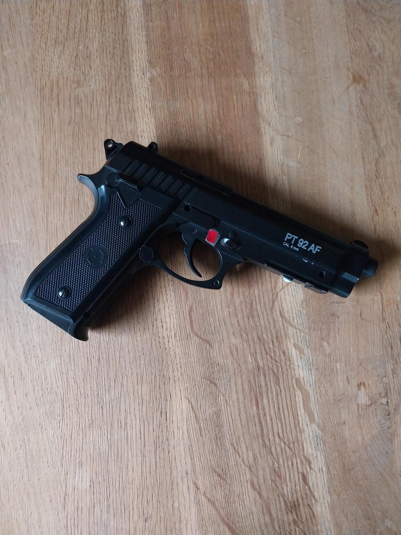 Imagen 1 de Cybergun PT92 AF 6mm met Weapon light Olight Baldr Pro, zak met balletjes en 4 Cartouches CO2