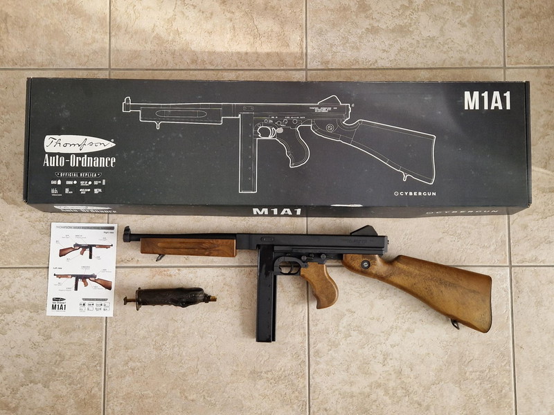 Afbeelding 1 van De Cybergun Thompson M1A1 GBB in originele doos. Vraagprijs 275 Euro.