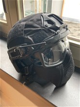 Afbeelding van zwarte fast-helm met zwarte cover zwarte facemask en bril